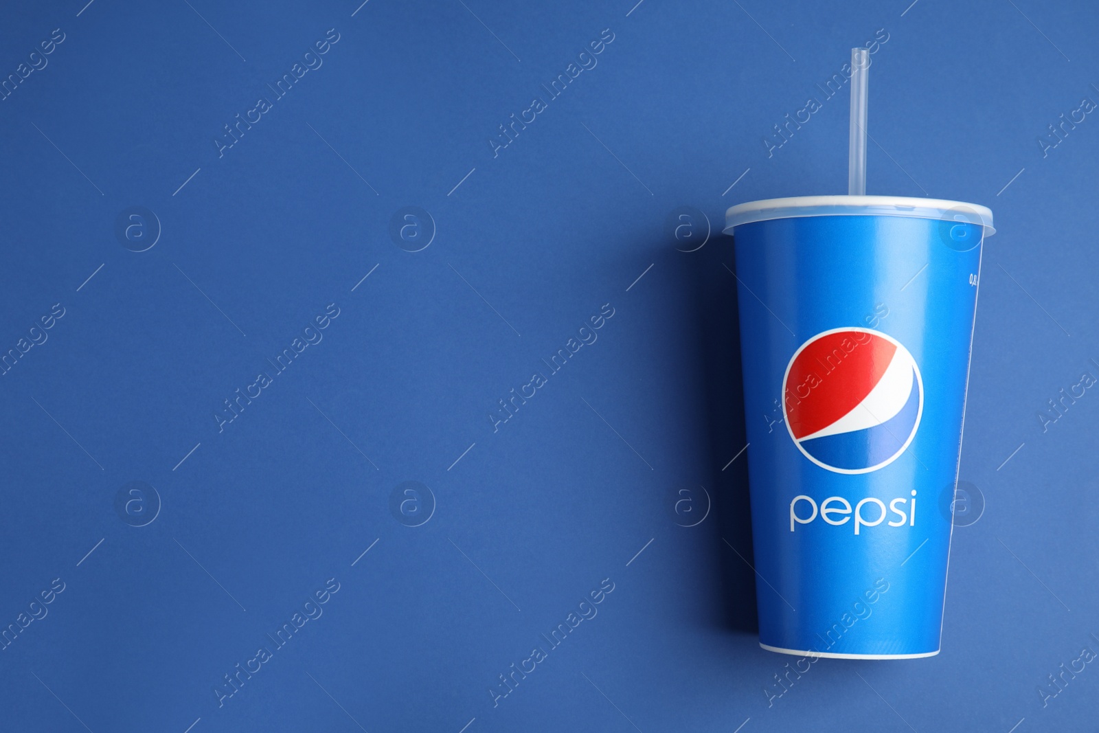 Photo of MYKOLAIV, UKRAINE - JUNE 08, 2021: Paper Pepsi cup on blue background, top view. Space for text