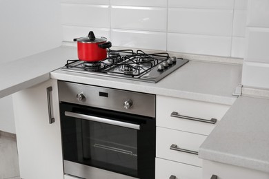Photo of Red pot on gas stove in kitchen