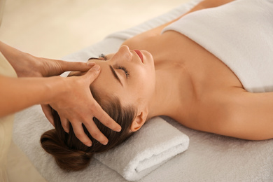 Young woman receiving head massage in spa salon