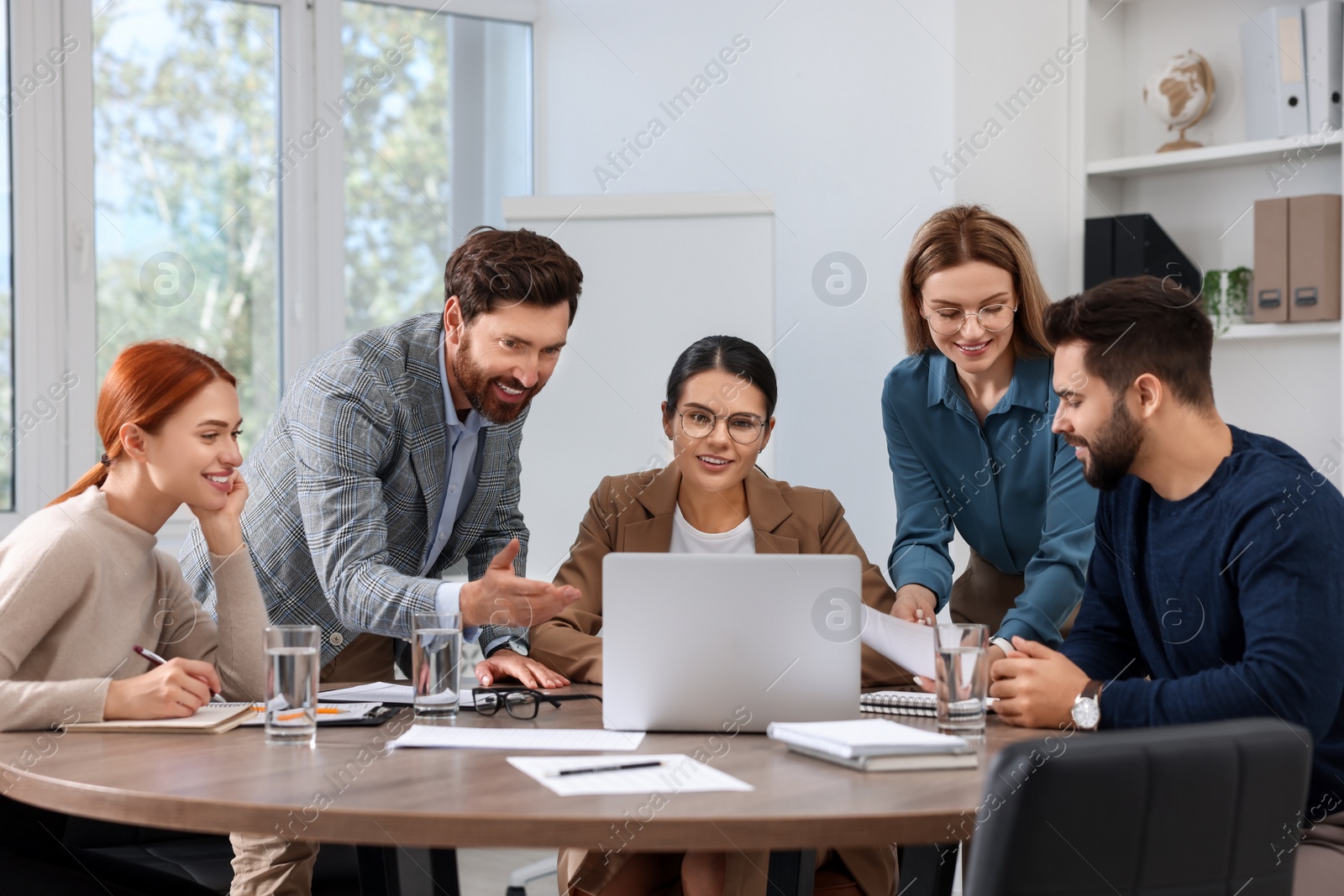 Photo of Team of employees working together in office