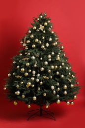 Beautifully decorated Christmas tree on red background