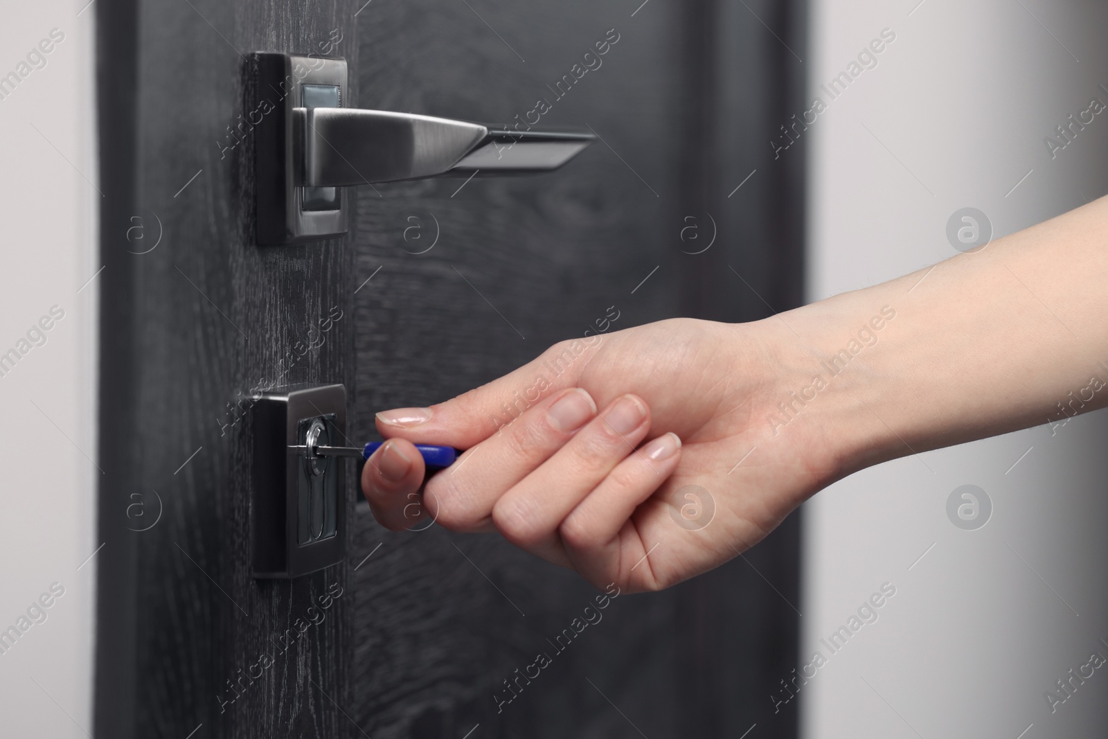 Photo of Woman unlocking door with key, closeup view