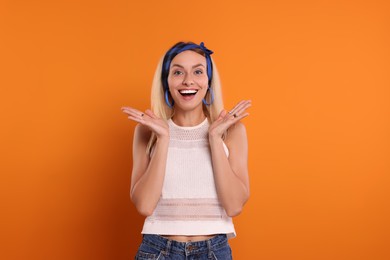 Photo of Portrait of excited hippie woman on orange background