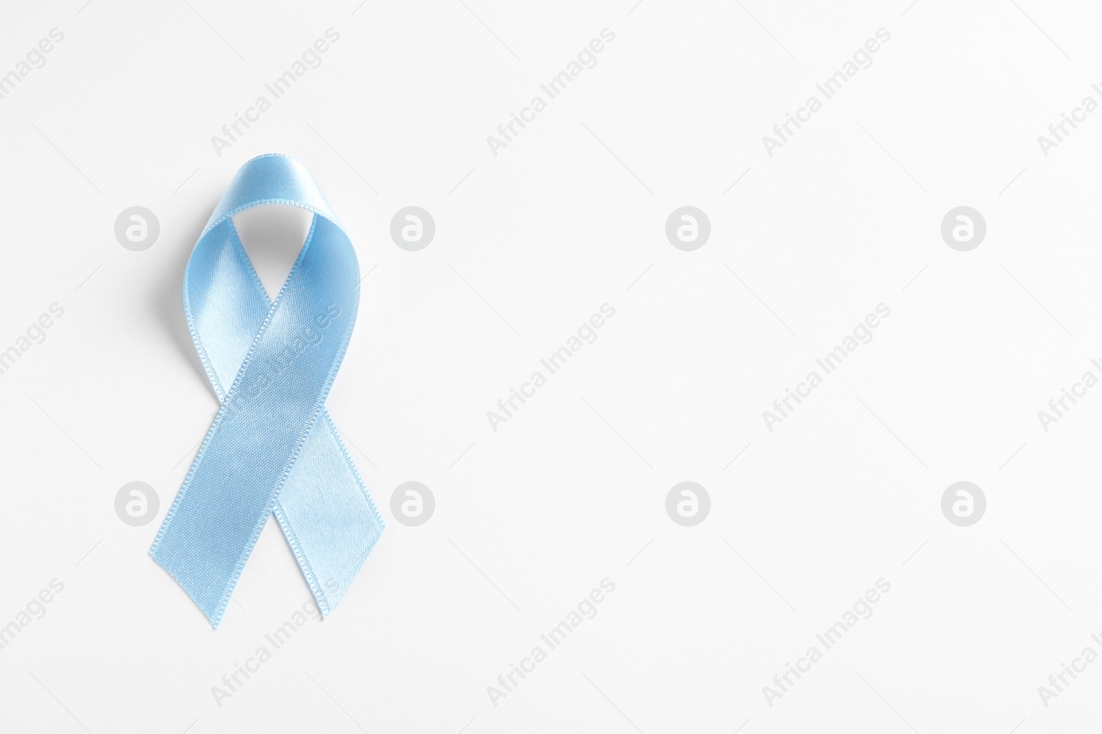 Photo of Blue ribbon on white background, top view. Cancer awareness