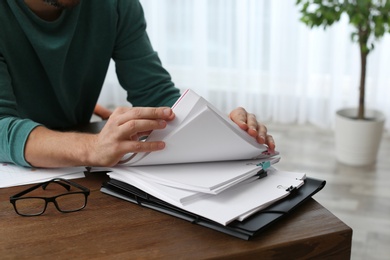 Businessman working with documents at office table, closeup