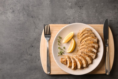 Photo of Tasty fresh lemon chicken served on grey table, top view.Space for text
