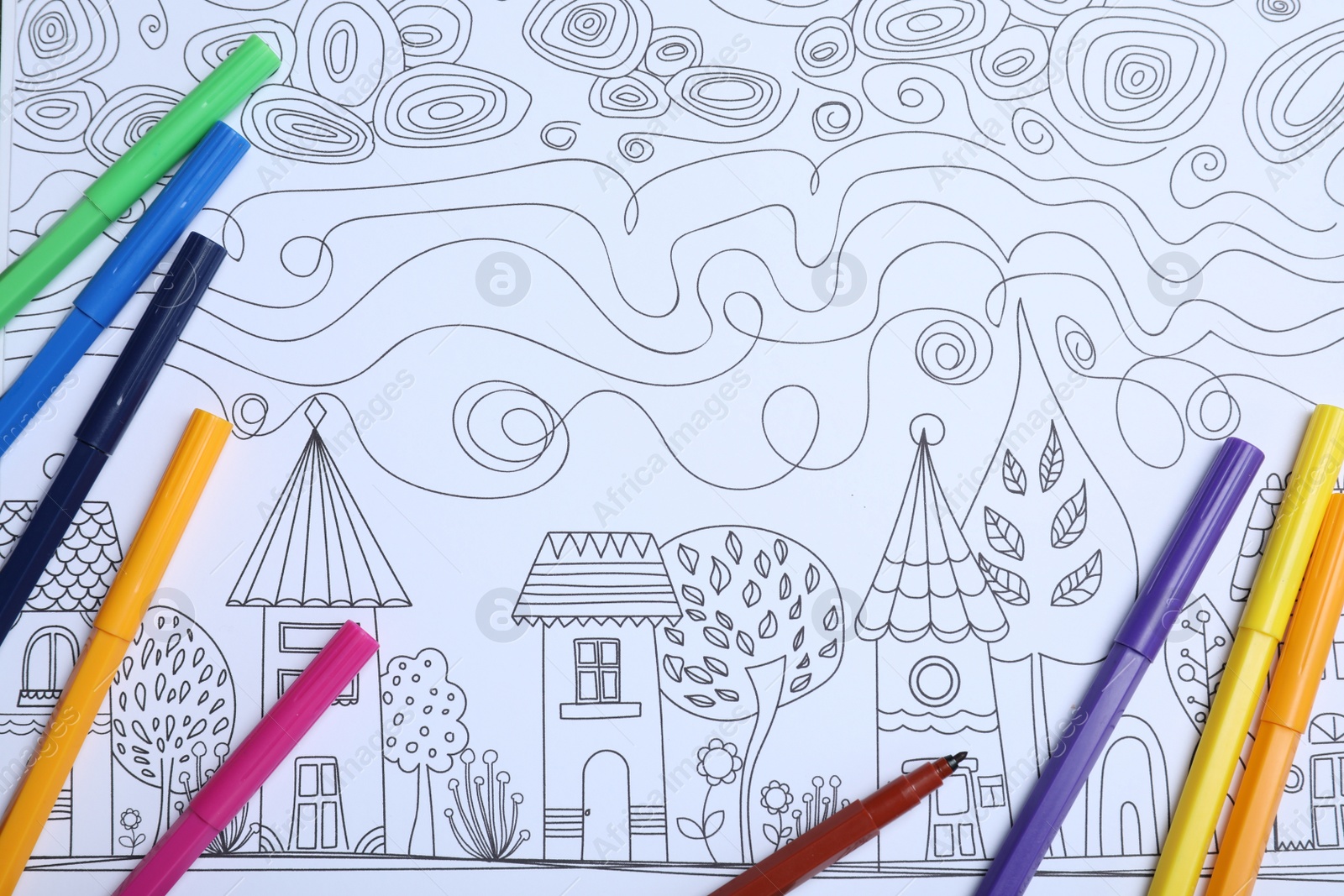 Photo of Felt tip pens on antistress coloring page, top view