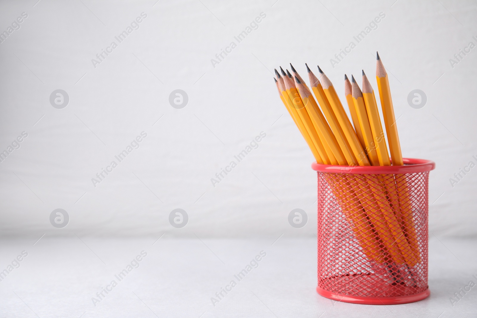 Photo of Many sharp pencils in holder on white background, space for text