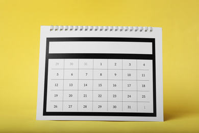 Photo of Paper calendar on yellow background. Planning concept