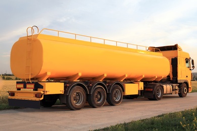 Photo of Modern yellow truck parked on country road