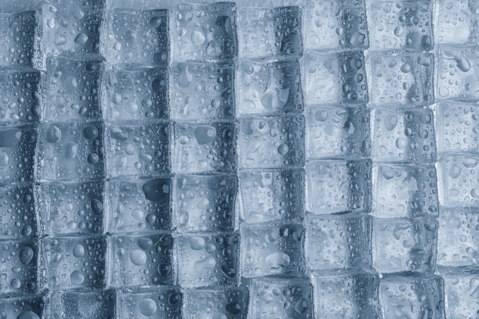 Photo of Crystal clear ice cubes with water drops as background, top view