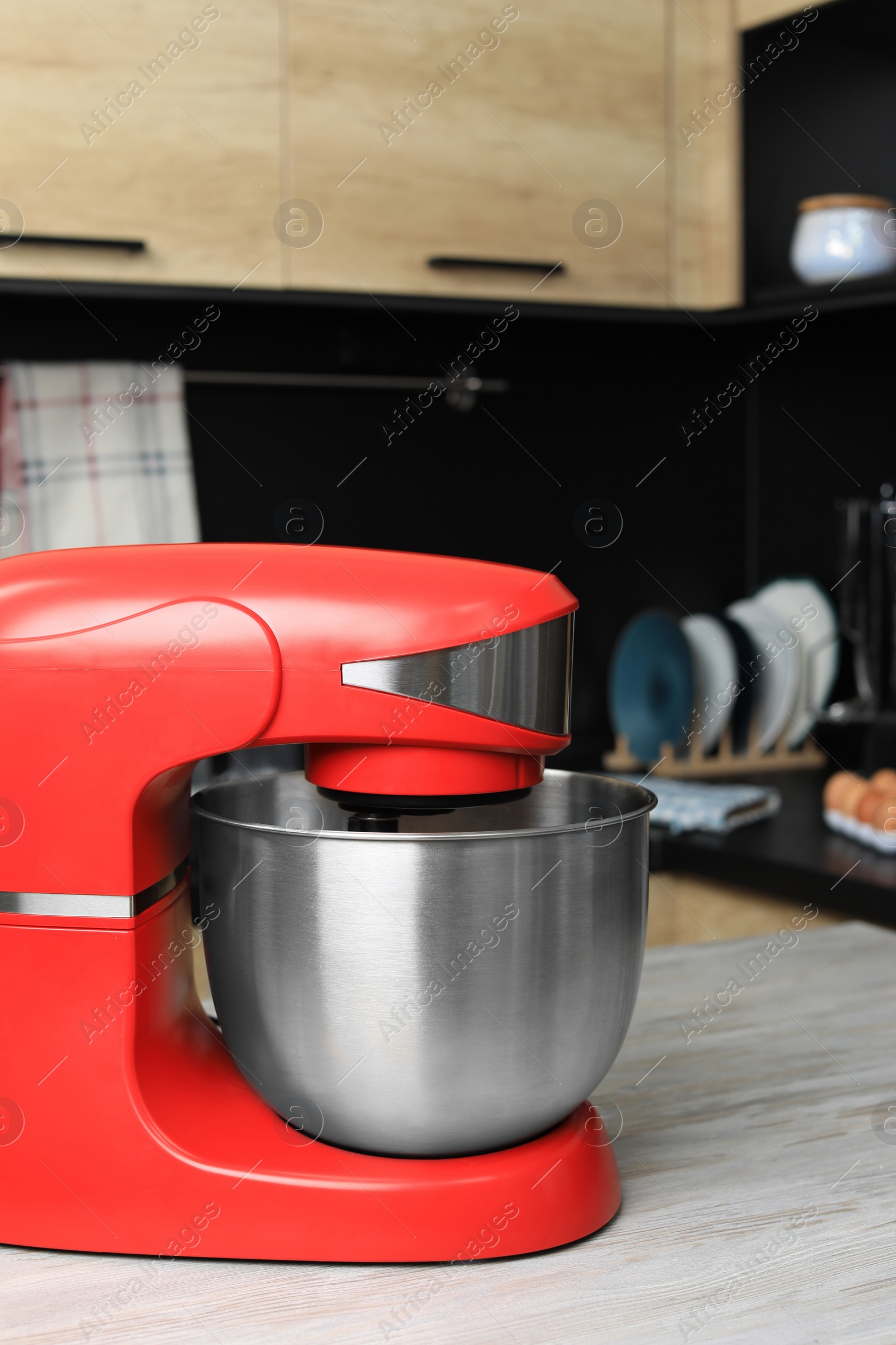 Photo of Modern stand mixer on wooden table in kitchen. Home appliance