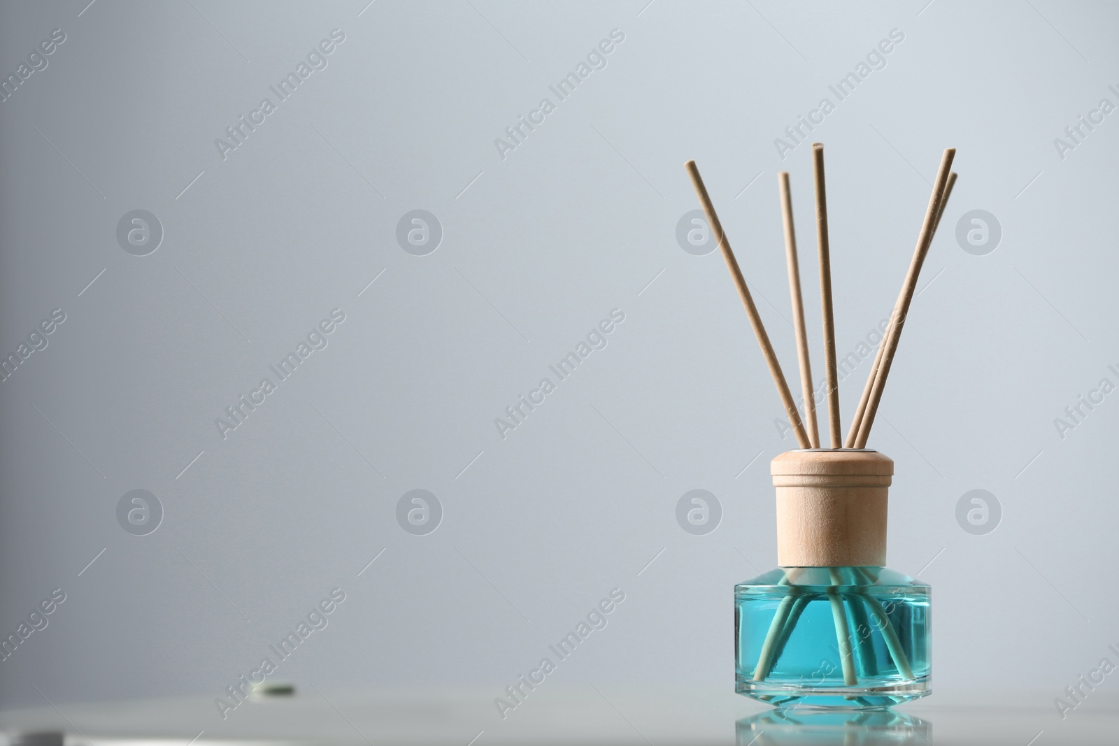 Photo of Reed air freshener on table indoors, space for text