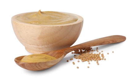 Fresh tasty mustard sauce in wooden bowl, spoon and dry seeds isolated on white