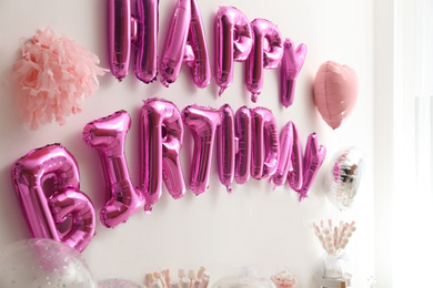 Phrase HAPPY BIRTHDAY made of pink balloon letters in decorated room