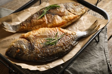 Photo of Delicious dorado fish with rosemary on table, closeup