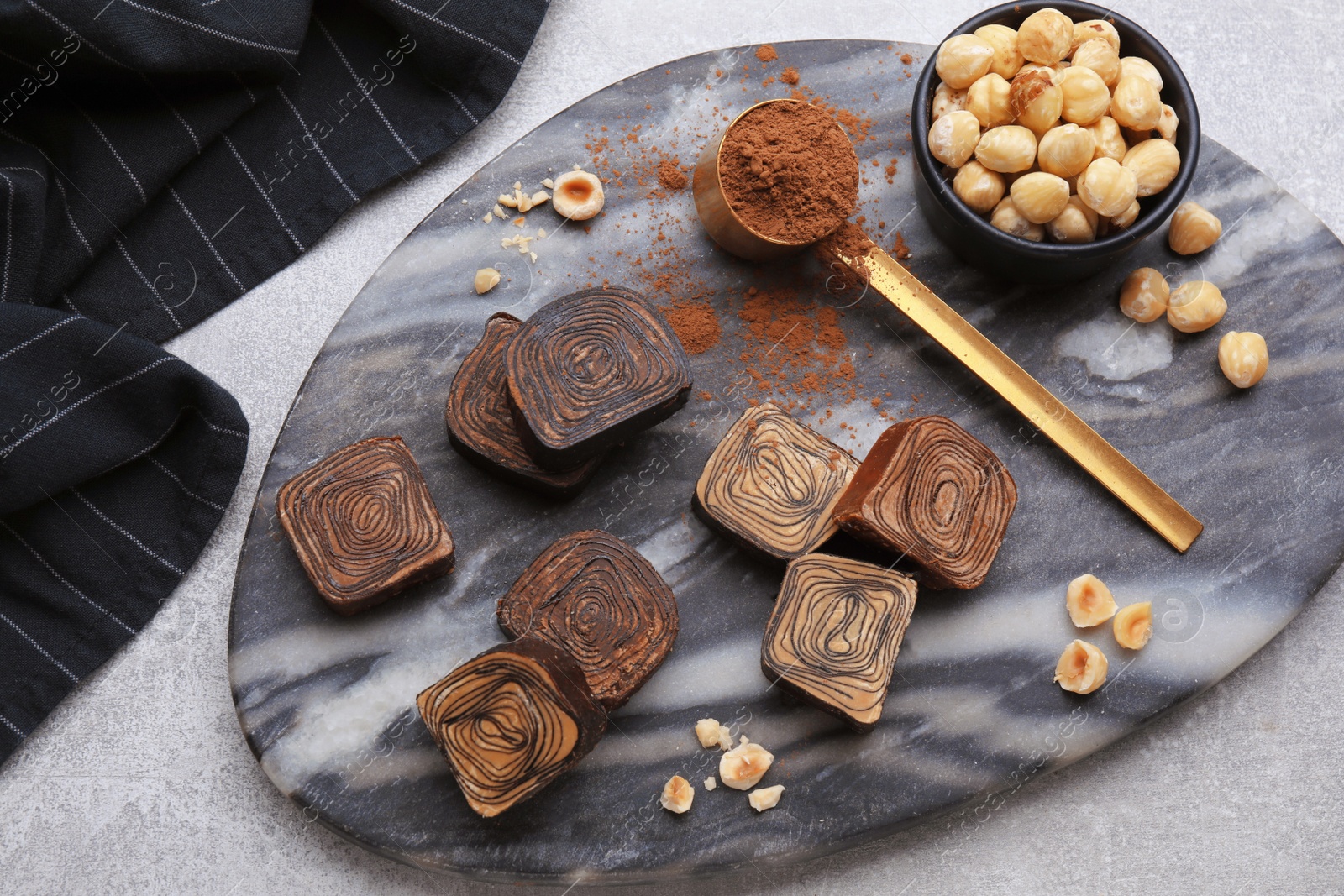 Photo of Flat lay composition with tasty chocolate candies and nuts on light grey table