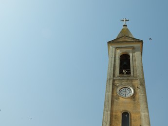 Beautiful church steeple with clock on sunny day, space for text