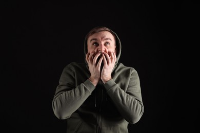 Photo of Portrait of emotional young man on black background. Personality concept
