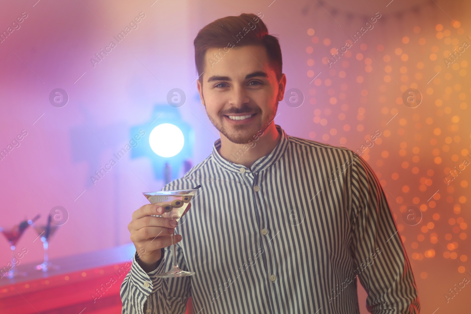 Photo of Young man with glass of martini cocktail at party