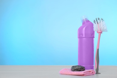 Photo of Bottle of cleaning product and supplies on light table. Space for text