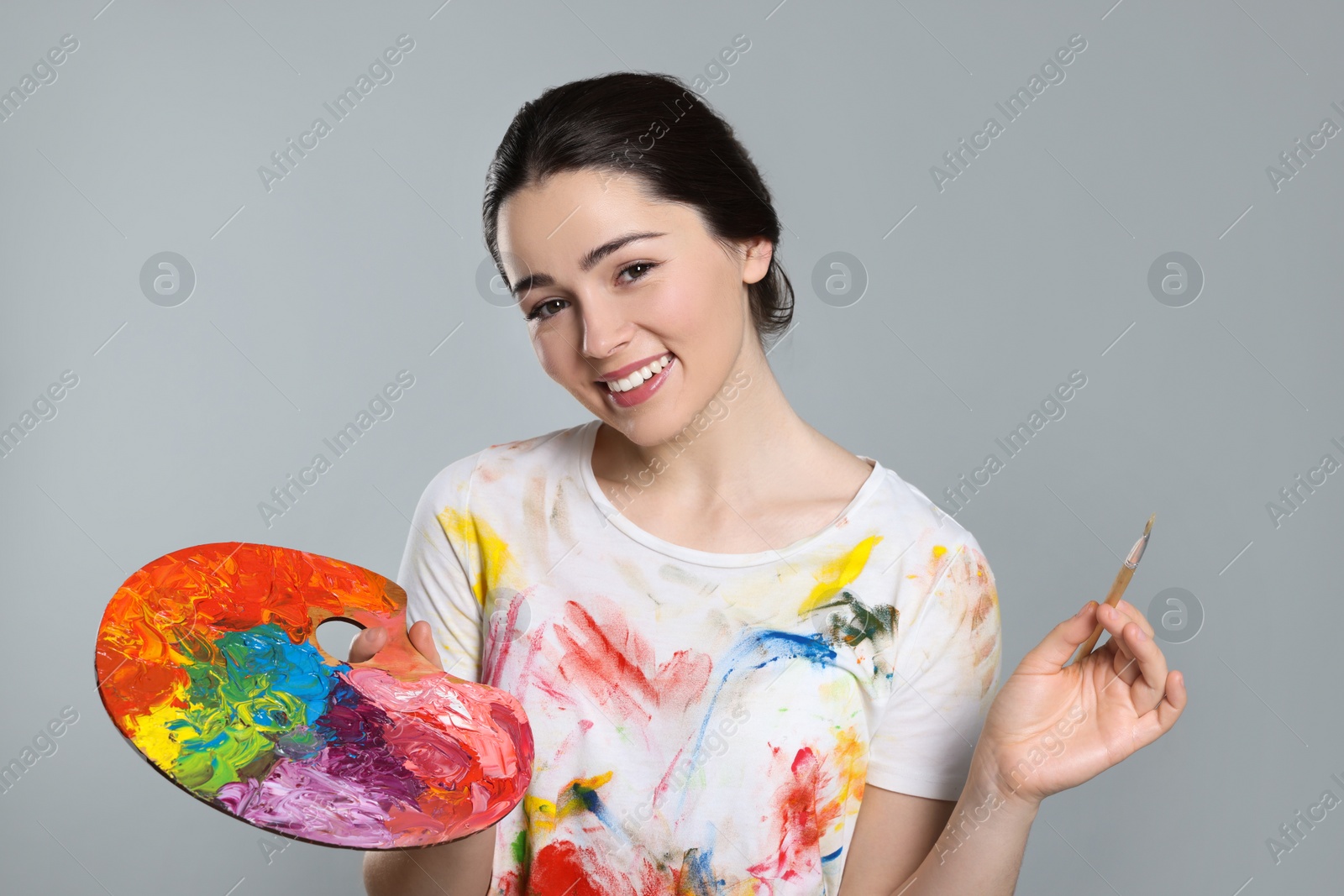 Photo of Woman with painting tools on grey background. Young artist