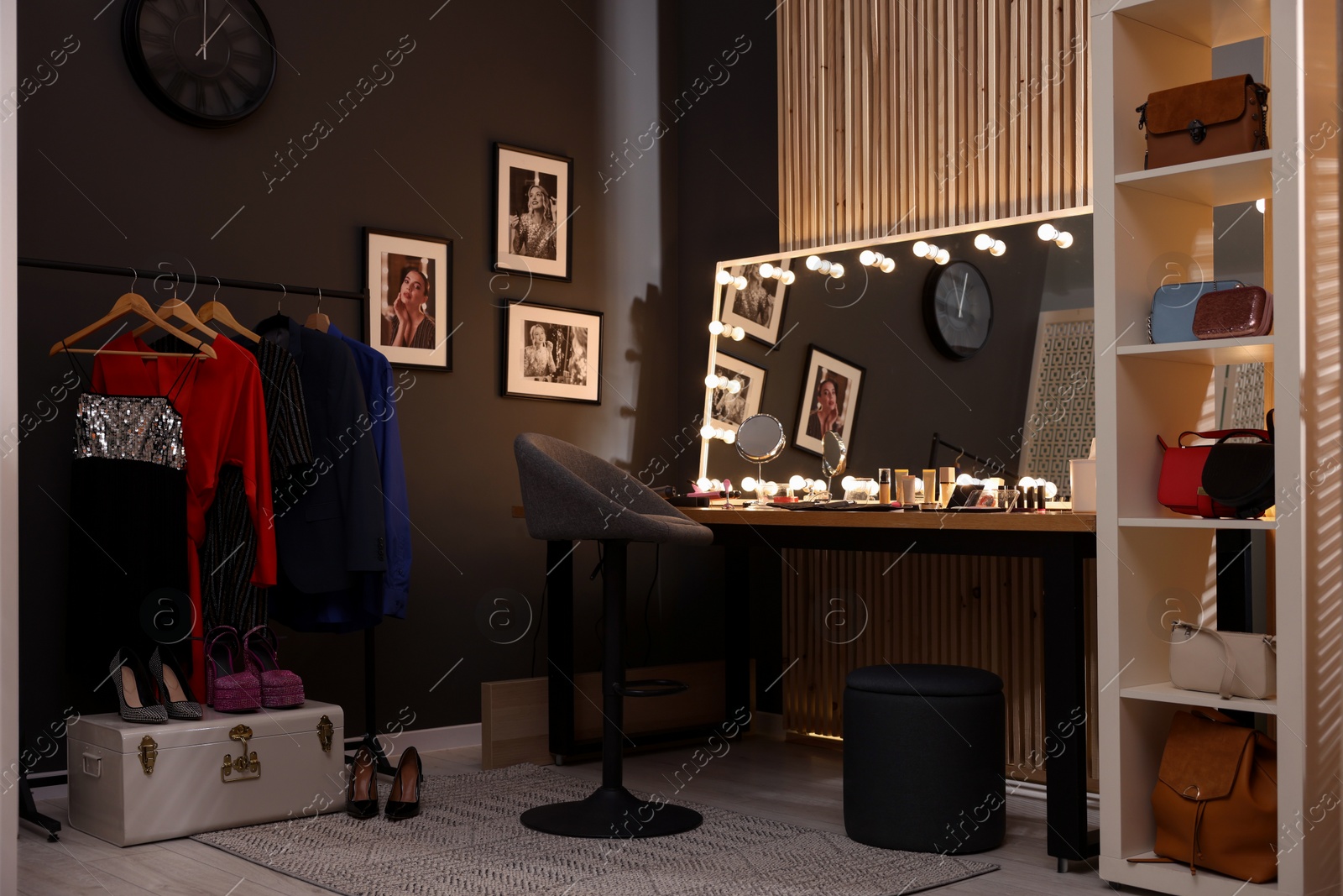 Photo of Chair, clothes rack and stylish mirror on dressing table in makeup room