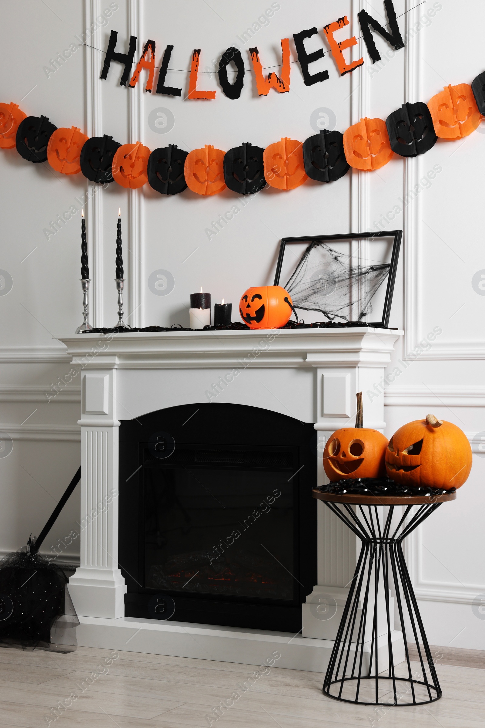 Photo of Stylish room with fireplace decorated for Halloween