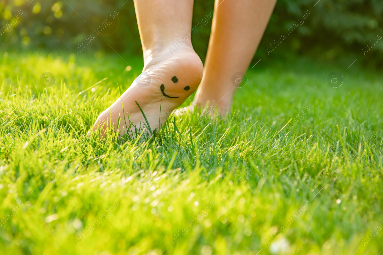 Photo of Teenage girl with smiling face drawn on heel walking outdoors, closeup