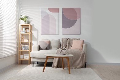 Photo of Stylish living room interior with sofa, coffee table and wooden shelf