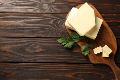 Photo of Tasty butter and parsley on wooden table, top view. Space for text