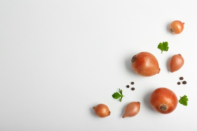 Flat lay composition with ripe onions on light background