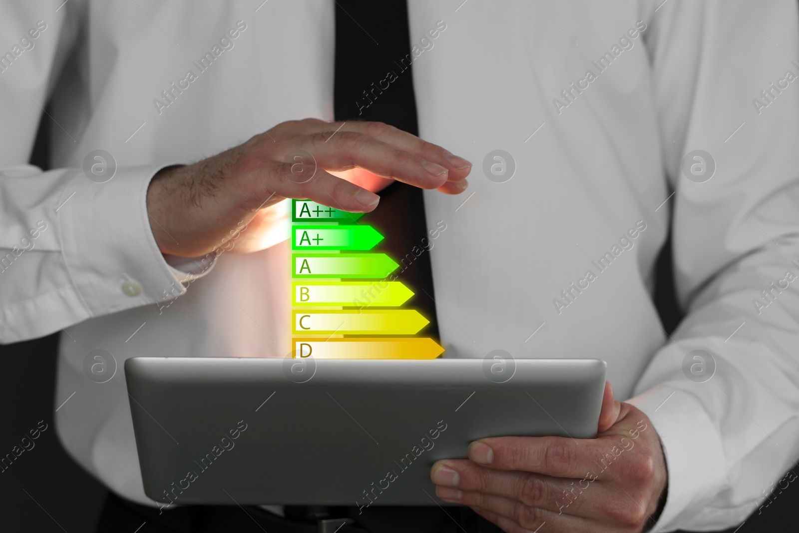 Image of Energy efficiency rating coming out of tablet. Man using device, closeup