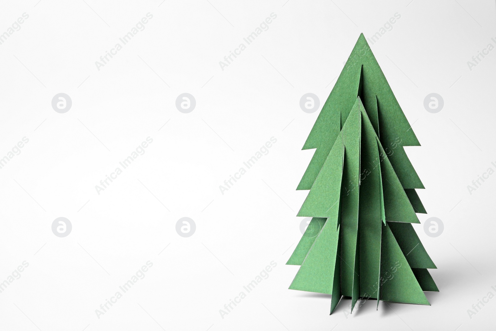 Photo of Christmas tree made of paper on white background