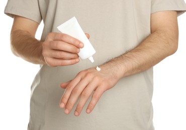 Man applying cream onto hand against white background, closeup