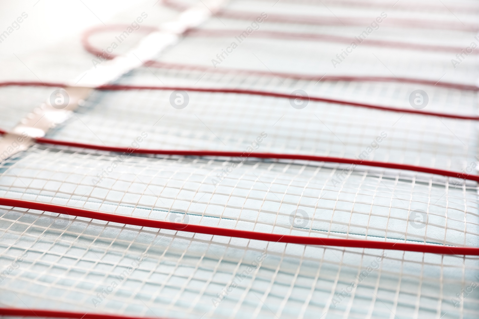 Photo of Installation of modern underfloor trace heating system indoors, closeup