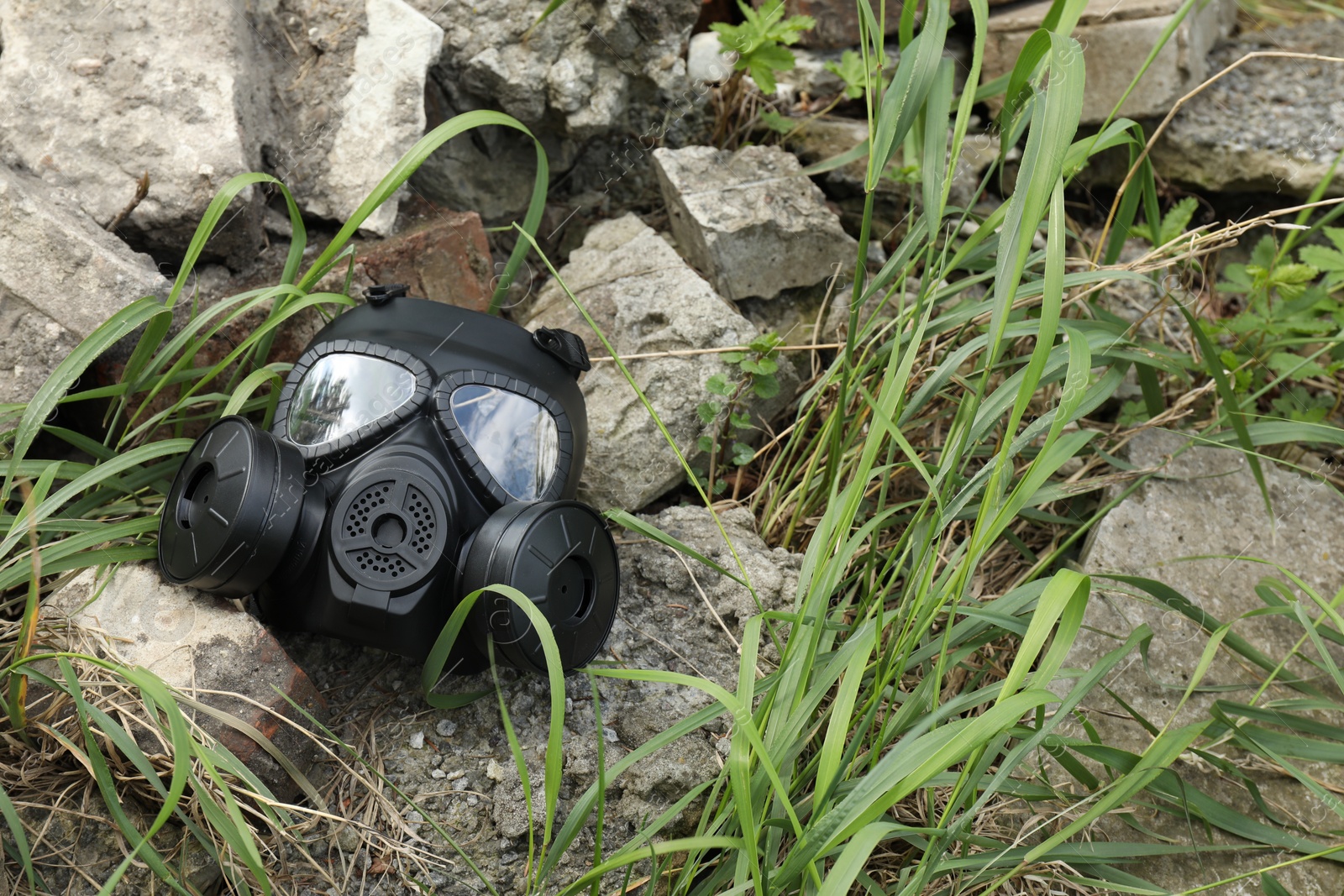 Photo of One gas mask on ground with stones outdoors