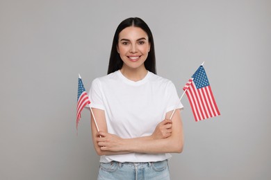 4th of July - Independence Day of USA. Happy woman with American flags on light grey background