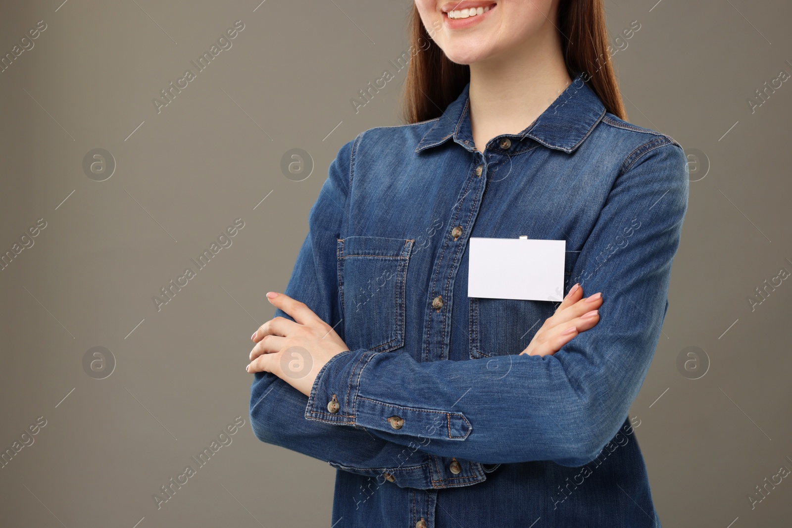 Photo of Woman with blank badge on grey background, closeup. Space for text