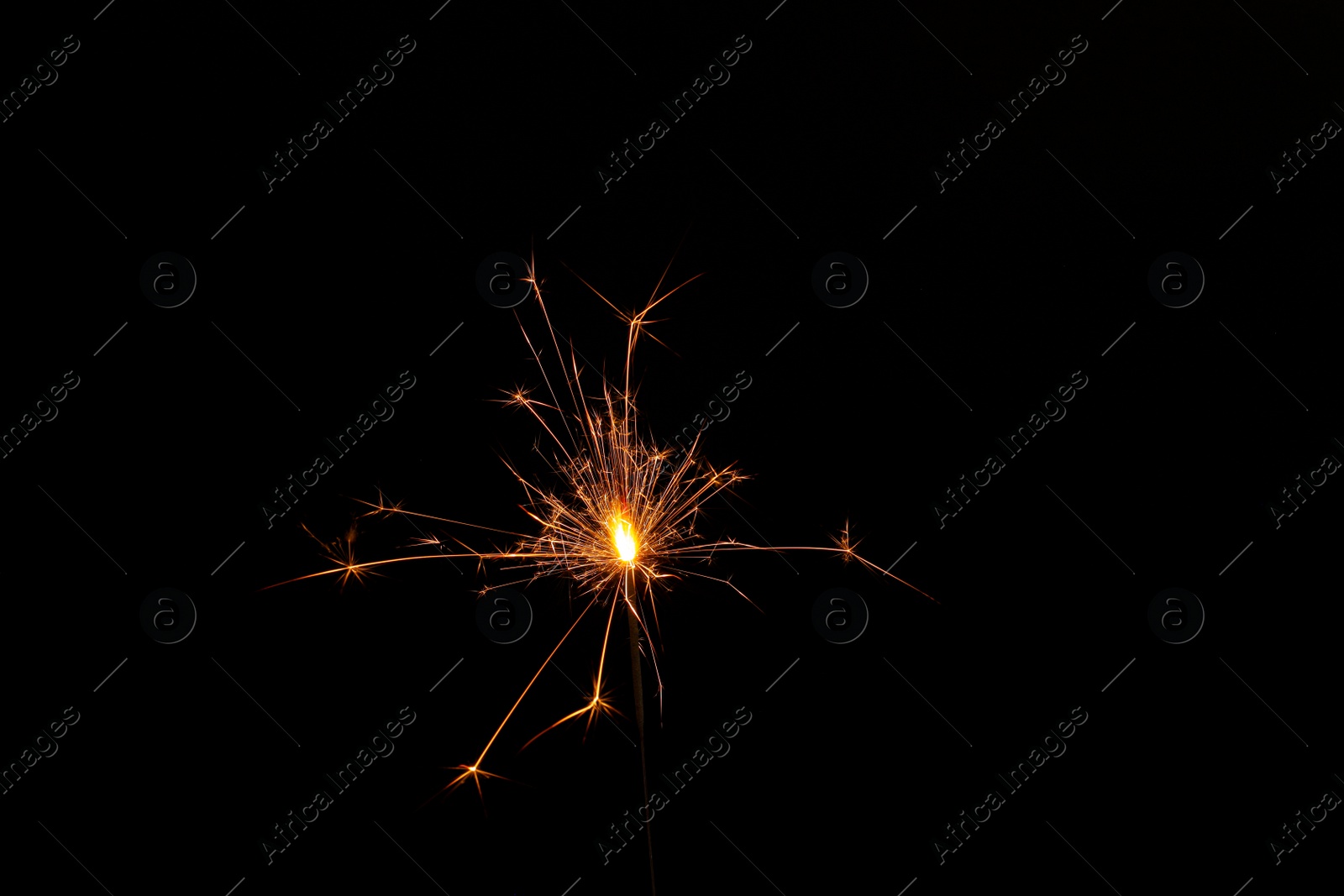 Photo of One burning sparkler stick on black background