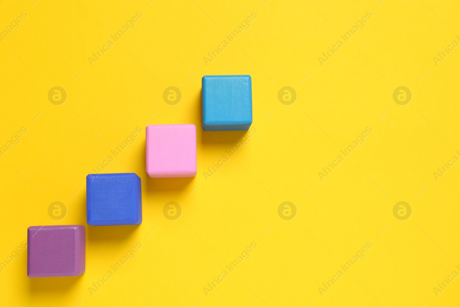 Photo of Many colorful cubes on yellow background, flat lay and space for text. Management concept