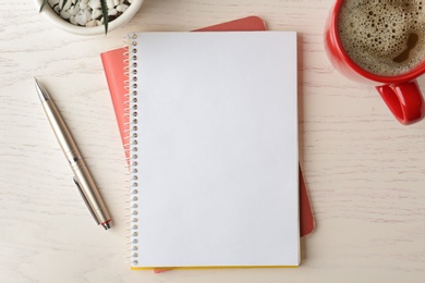 Photo of Flat lay composition with office stationery and cup of coffee on white wooden table. Space for design