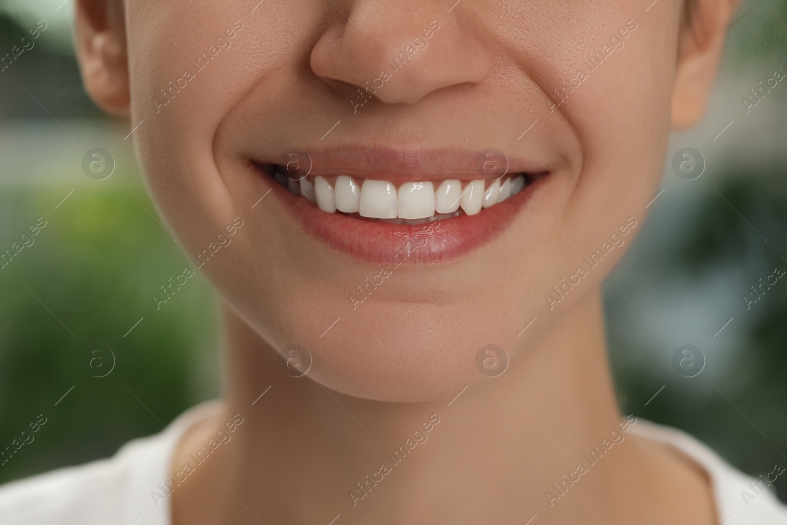 Photo of Woman with healthy teeth on blurred background, closeup