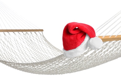 Photo of Comfortable hammock and Santa Claus hat on white background, closeup. Christmas vacation