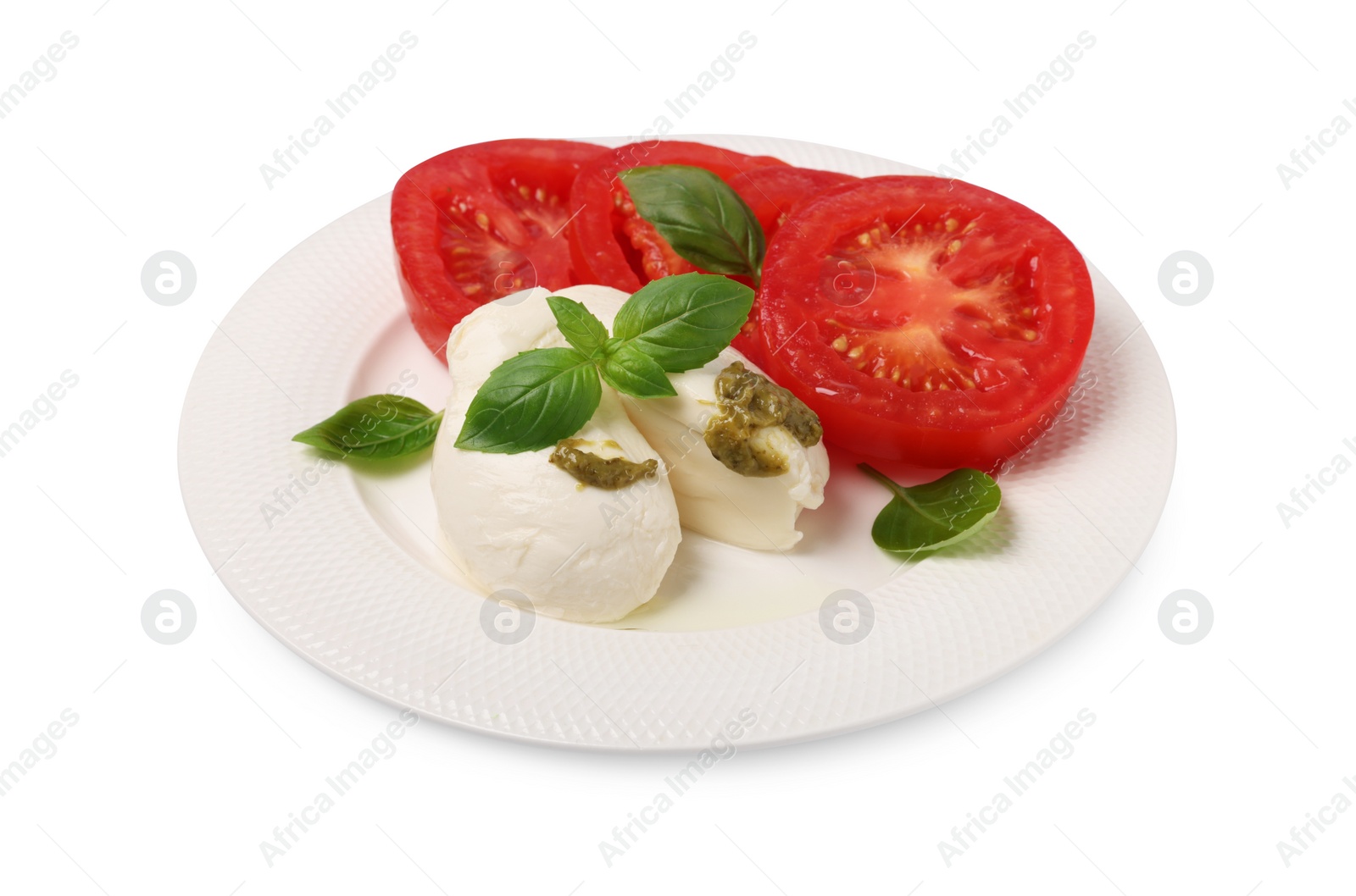 Photo of Plate of tasty Caprese salad with mozzarella, tomatoes, basil and pesto sauce isolated on white