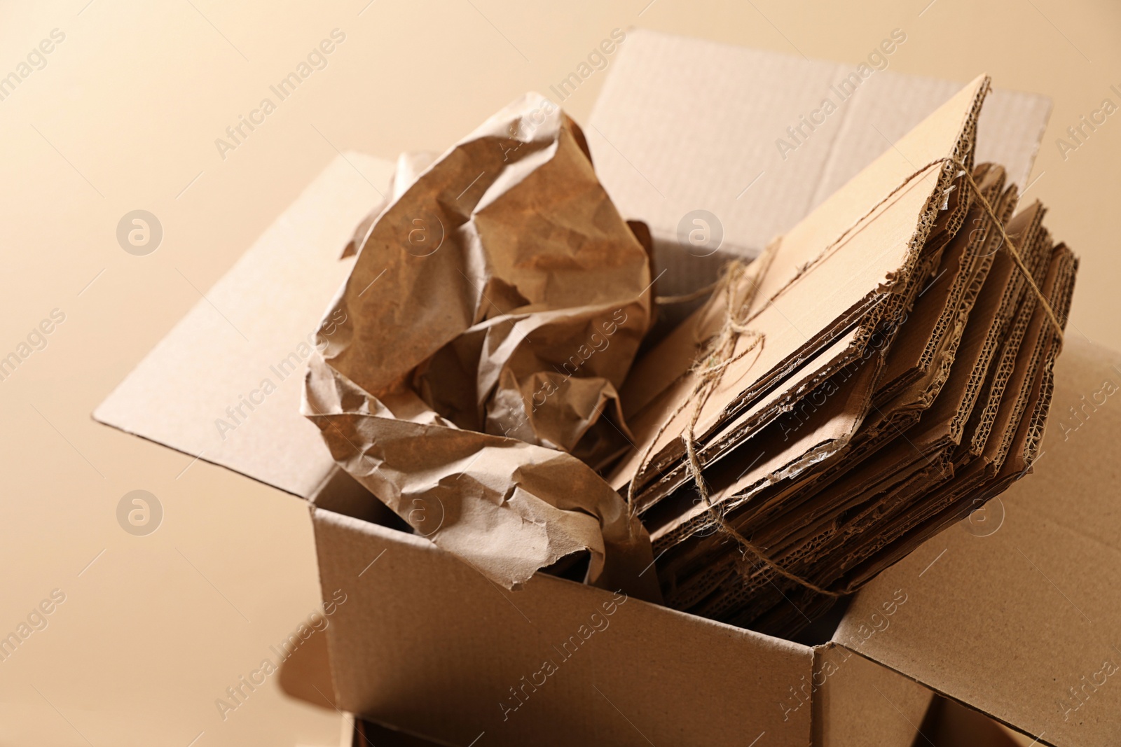 Photo of Heap of waste paper near beige wall, closeup