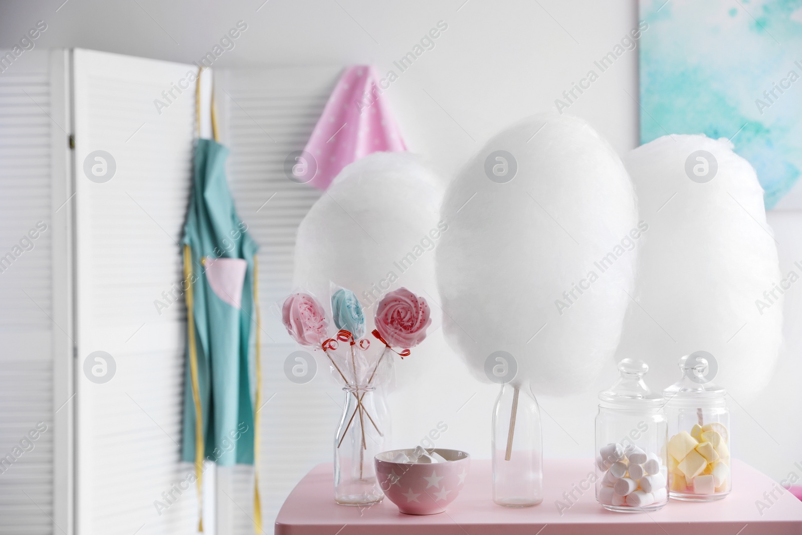 Photo of Tasty cotton candy and other sweets on table in room. Space for text