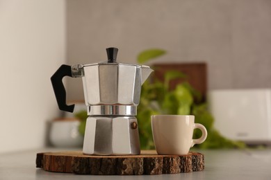 Photo of Ceramic cup and moka pot on light countertop in kitchen