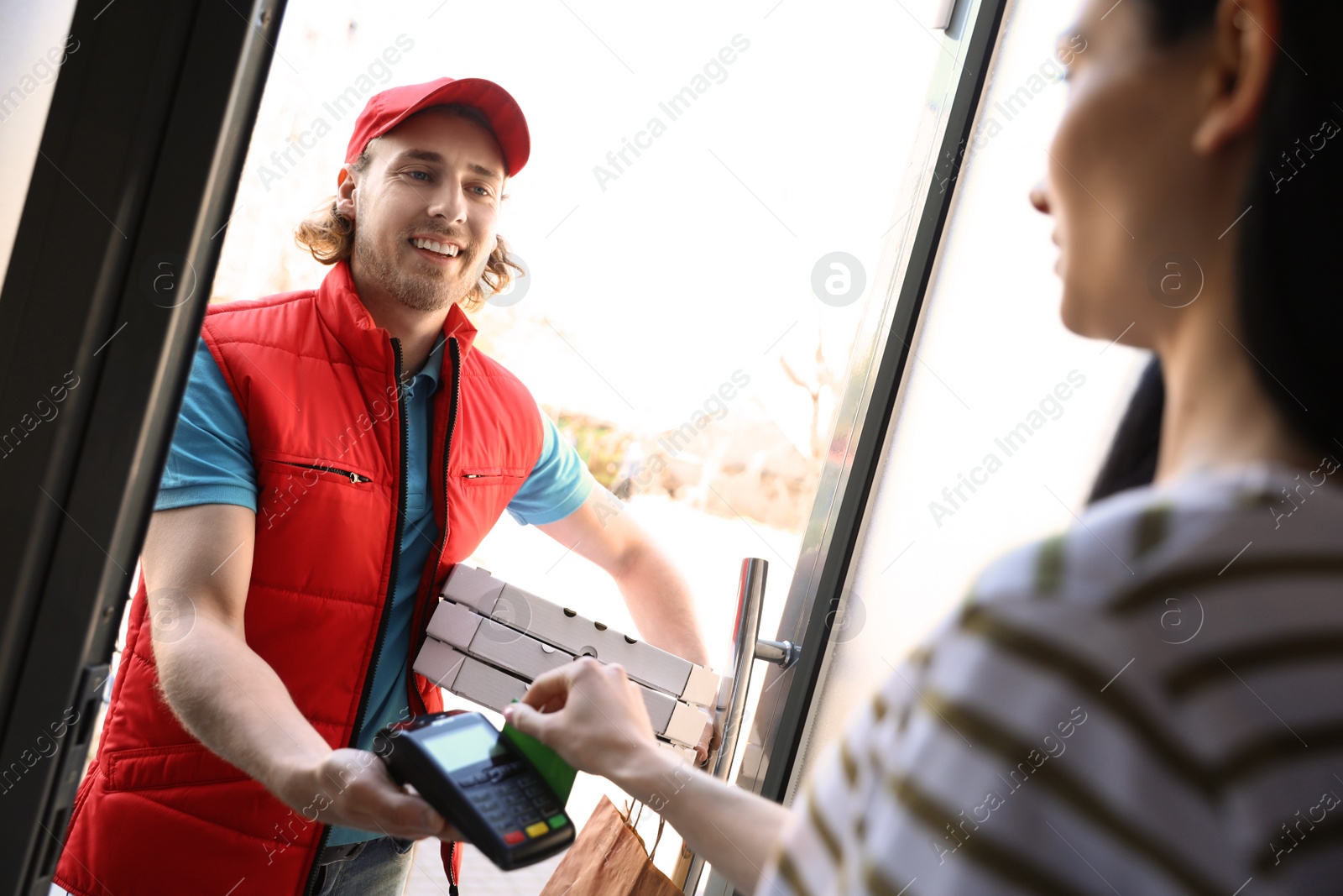 Photo of Woman paying for food delivery with credit card at door