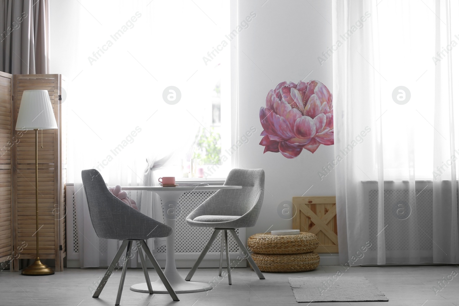 Photo of Stylish room interior with table and chairs near decorated wall